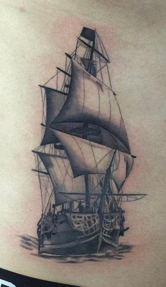 A black and white tattoo of a sailboat on a person 's stomach