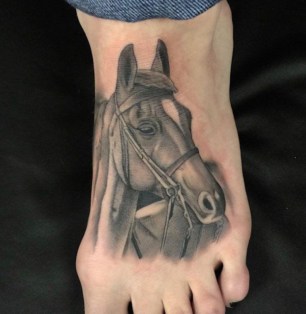 A person has a tattoo of a horse on their foot
