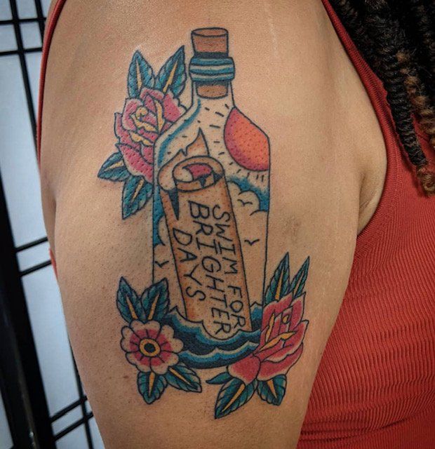 A woman has a tattoo of a bottle that says swim for brighter days