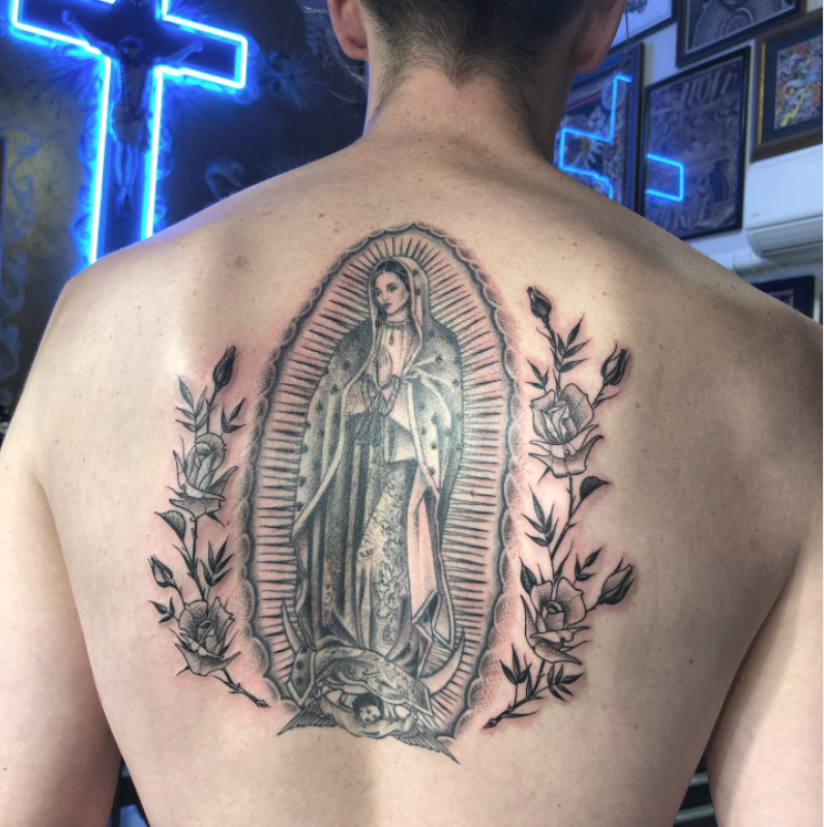 A woman has a tattoo of the virgin mary on her back