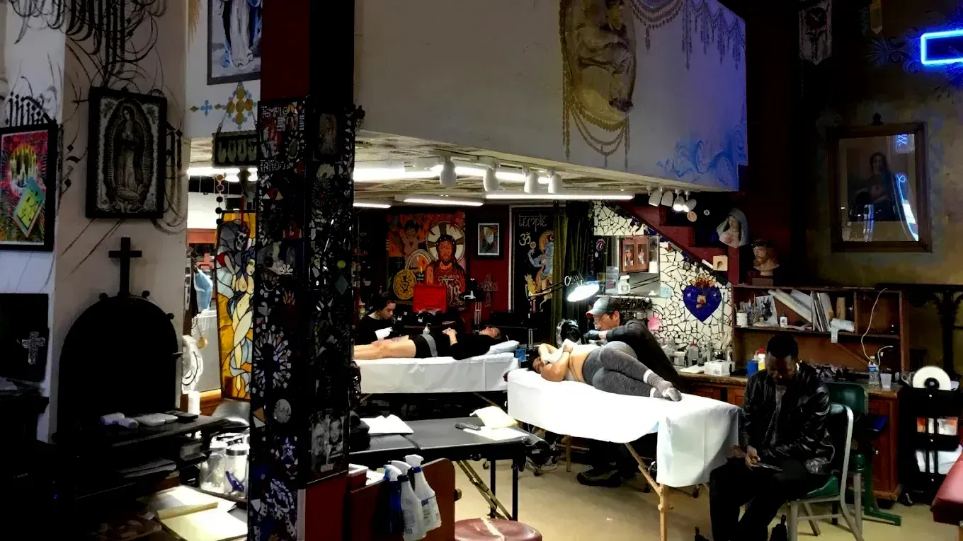 A man is getting a tattoo in a tattoo shop.