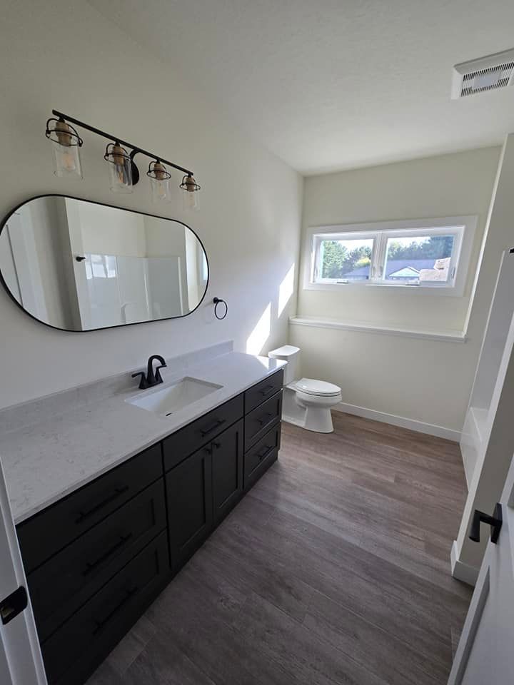 A bathroom with a sink , toilet and mirror.