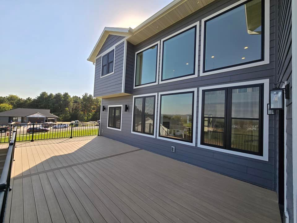 A large house with a large deck and lots of windows.