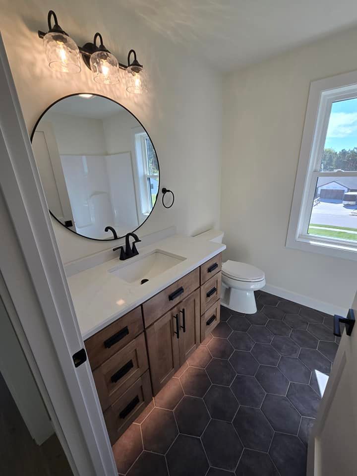 A bathroom with a sink , toilet and mirror.