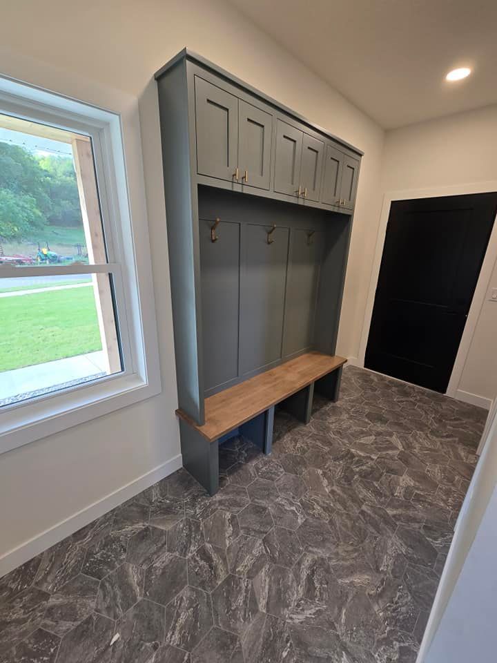 A mud room with a bench and a window.