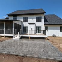 A large white house with a concrete patio in front of it.