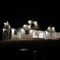 A large white house is lit up at night.