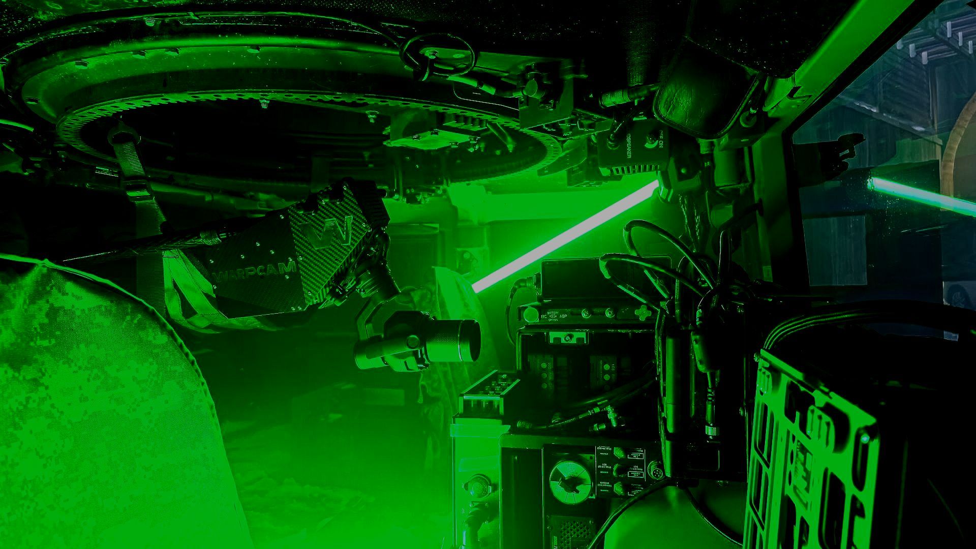 Image showcasing the compact and versatile setup of the WarpCam® system inside a cramped Humvee, surrounded by sophisticated electronic gear.