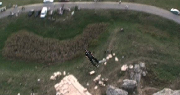 Top-down shot of Ferdi Fischer mid-air halfway through the 45 meter free fall, descending toward the cardboard box catcher at Burgsteinfelsen Dollnstein Bavaria