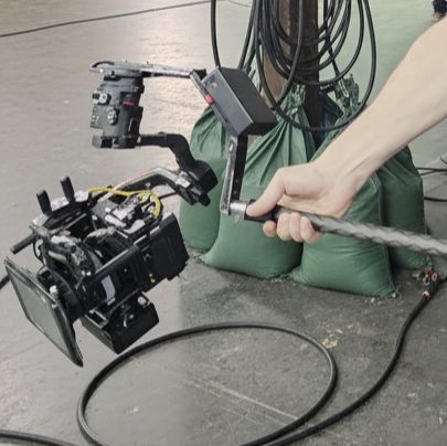 Close-up view of the HyperWarpCam® pole-mounted high-speed camera rig showing compact design and controlled handheld operation by SlamArtist.com