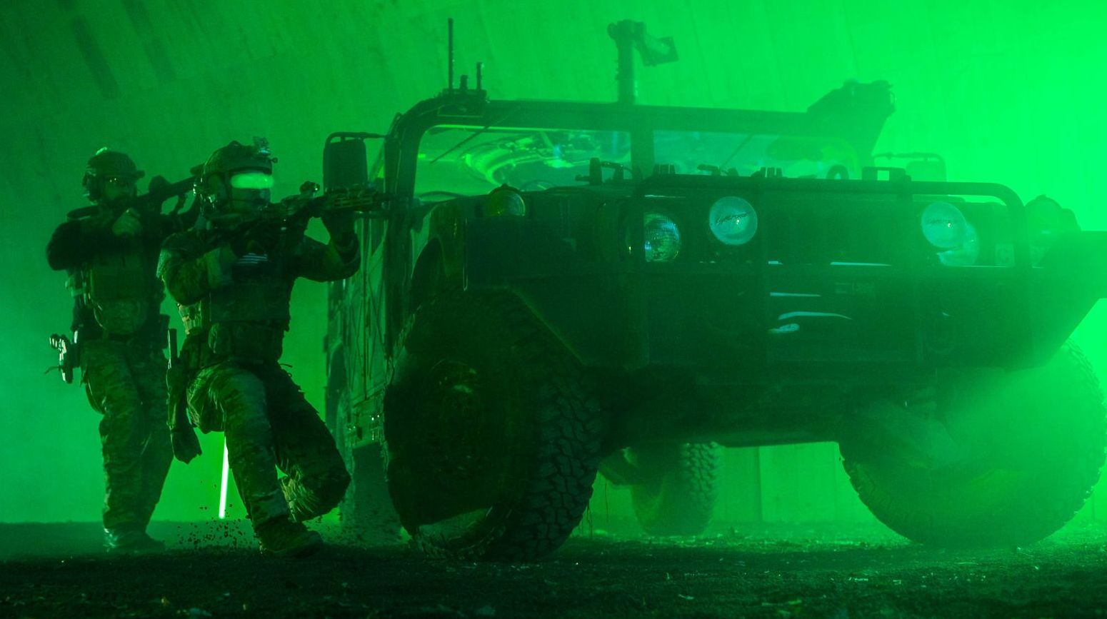 Two operators taking cover behind a Humvee, poised to engage a target, captured with the high-definition clarity of WarpCam®.