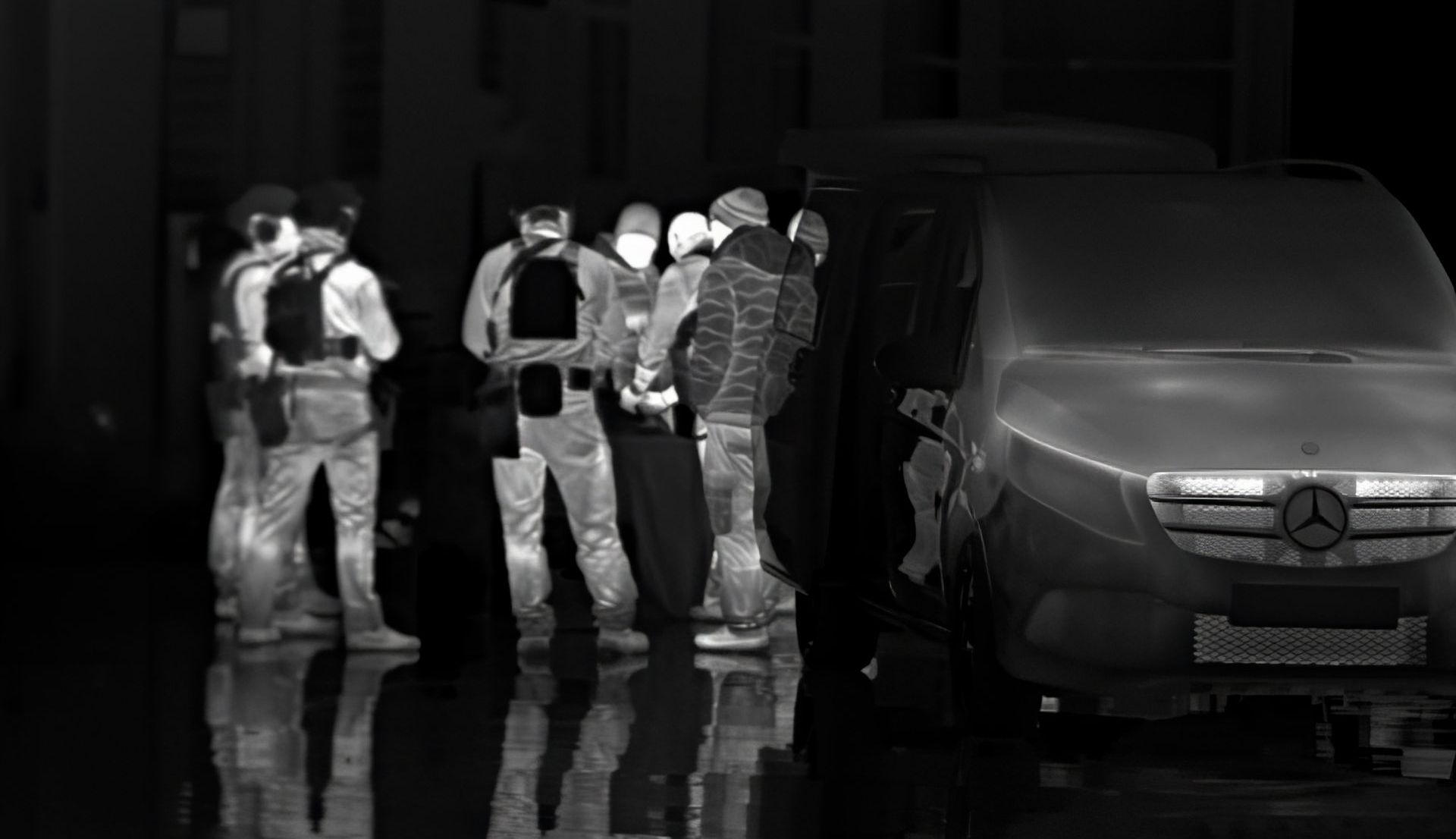 Thermal image showing the heat signatures of tactical operators gearing up for a mission, standing next to a Mercedes Viano.