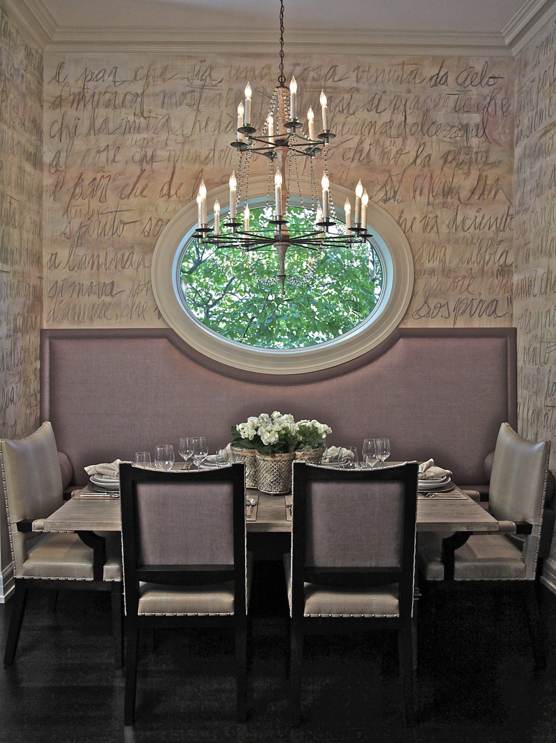 A dining room with a round window and a chandelier