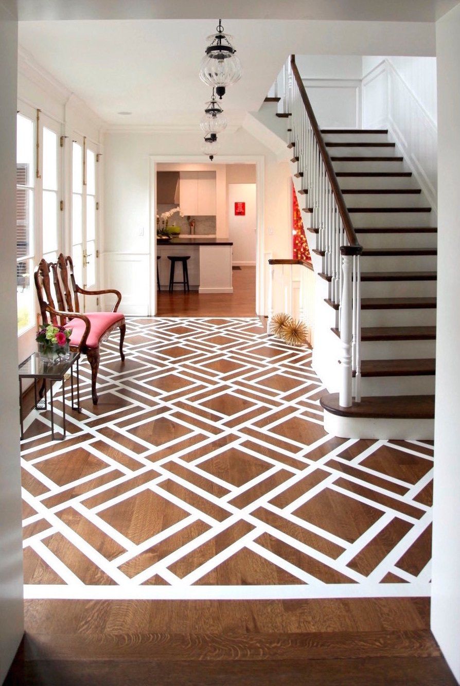 A hallway with a staircase and a rug on the floor