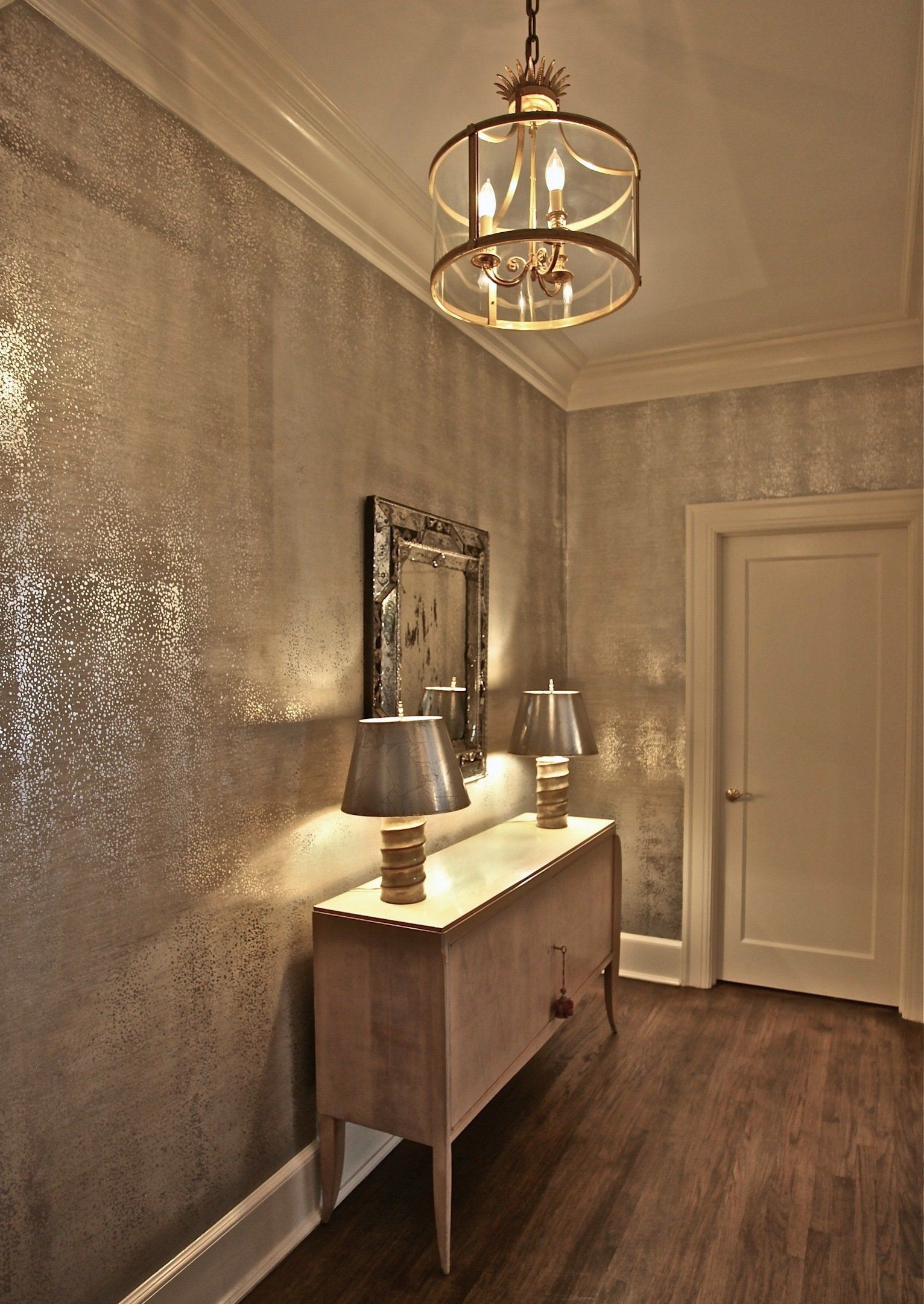 A hallway with a dresser and two lamps