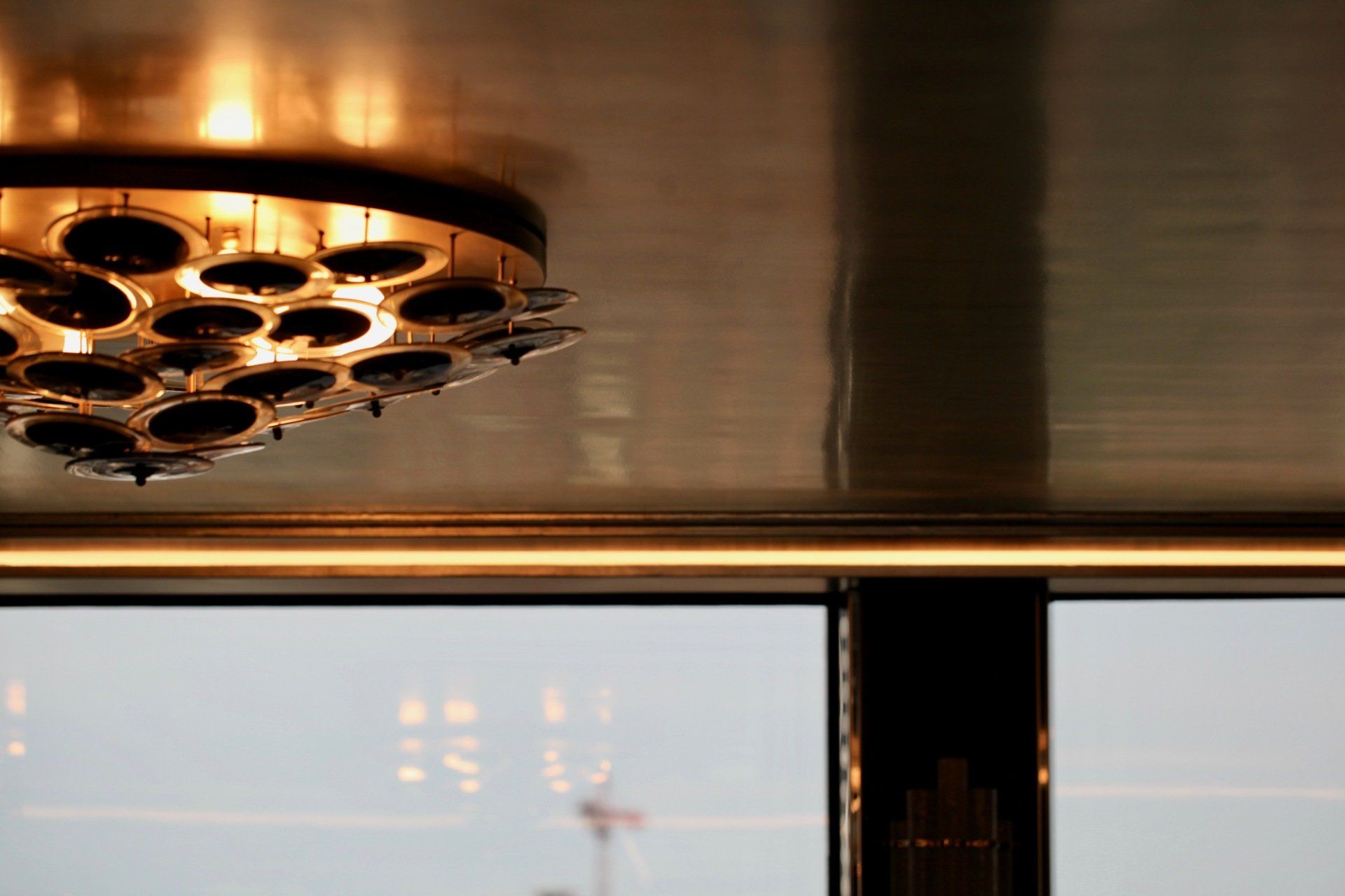 A close up of a ceiling light with a window in the background.