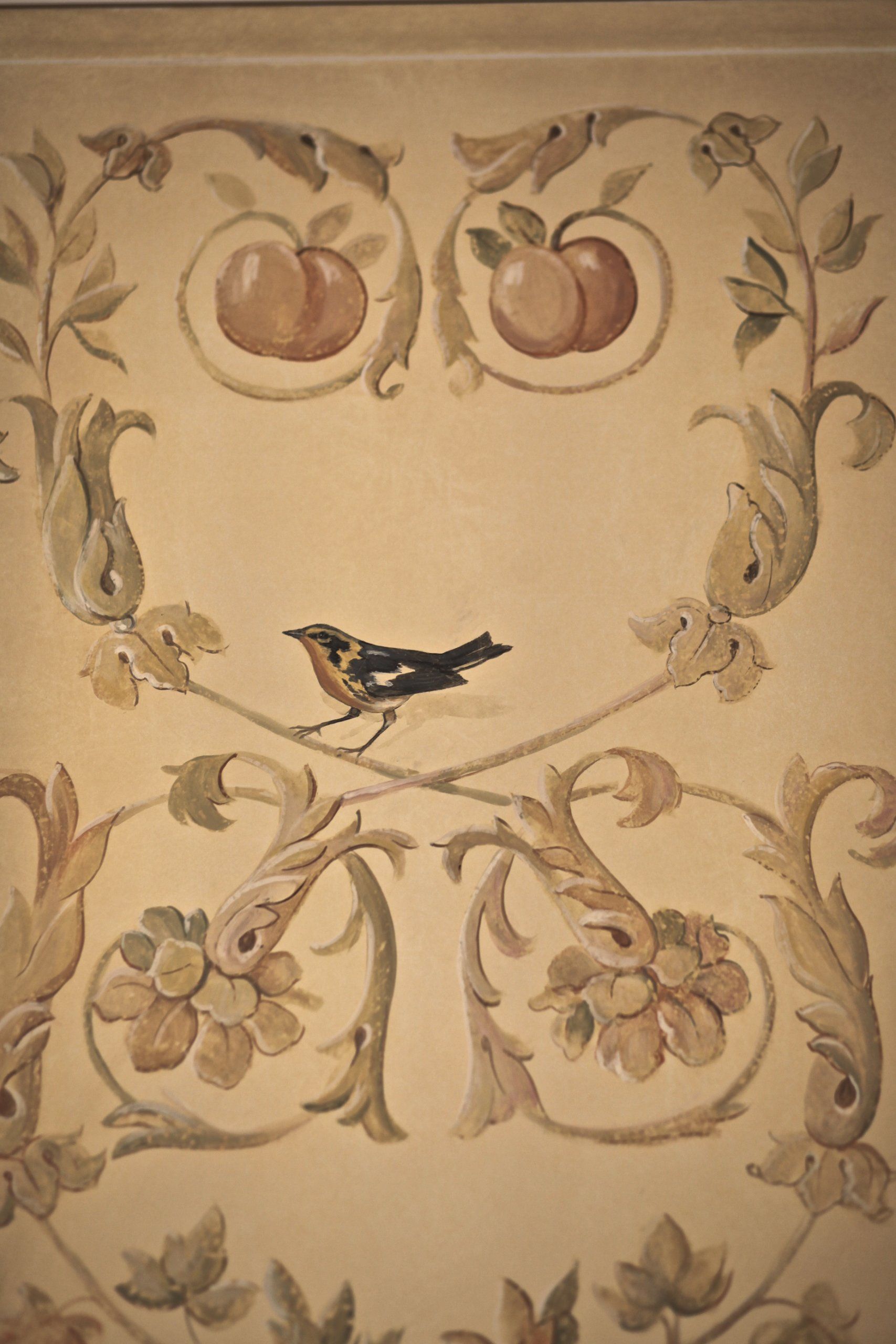 A bird is sitting on a branch with apples on it.