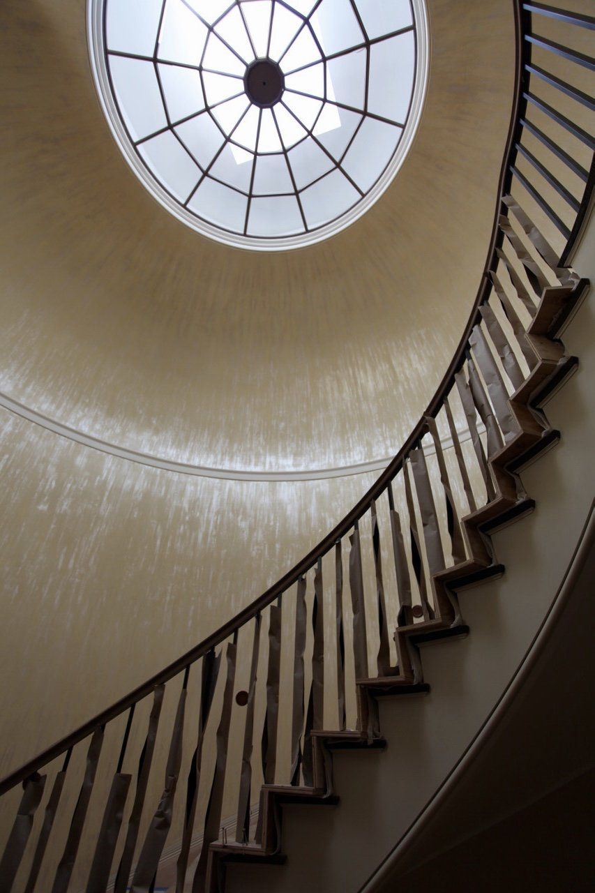 Looking up at a spiral staircase with a dome above it