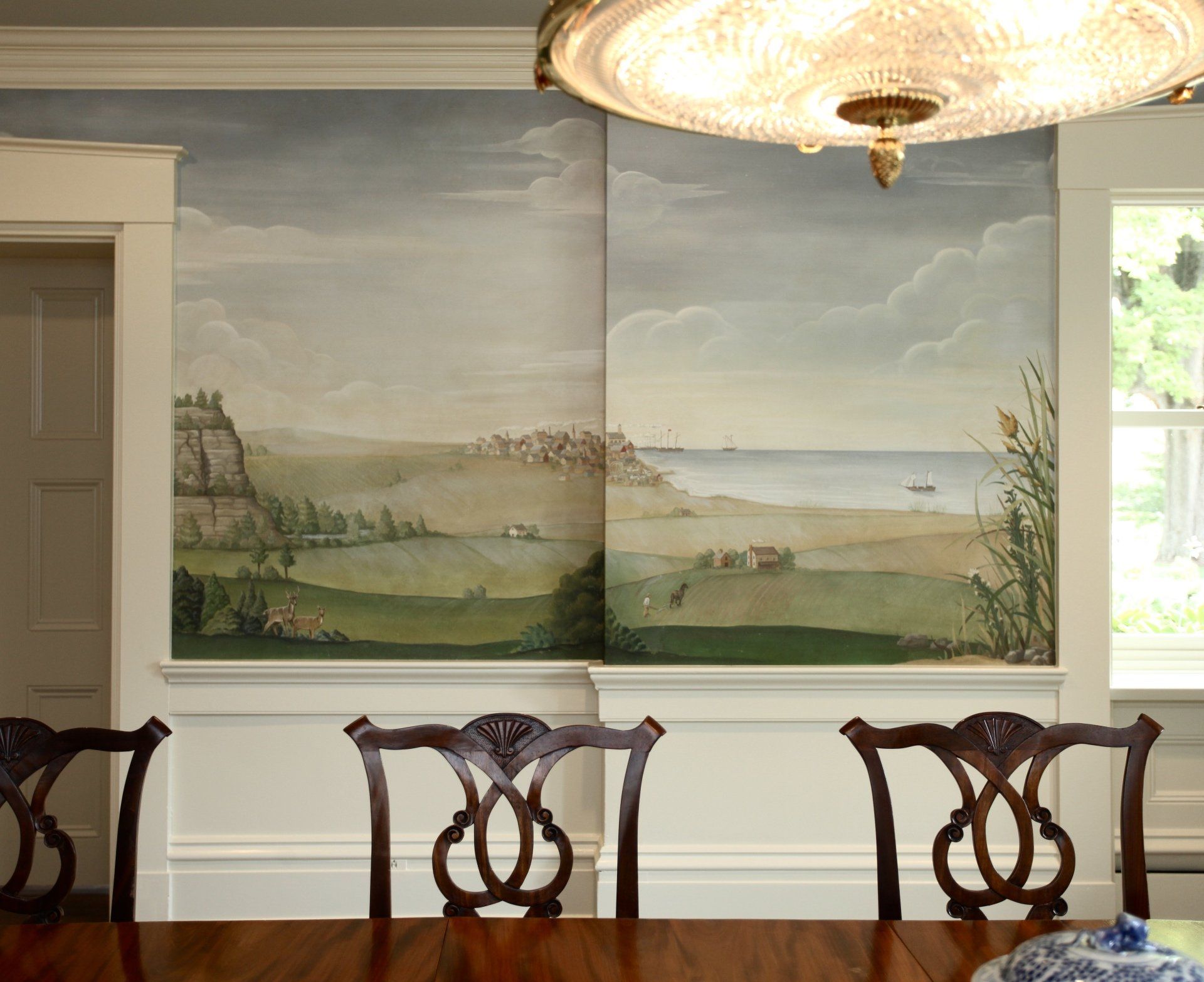 A dining room with a large painting on the wall