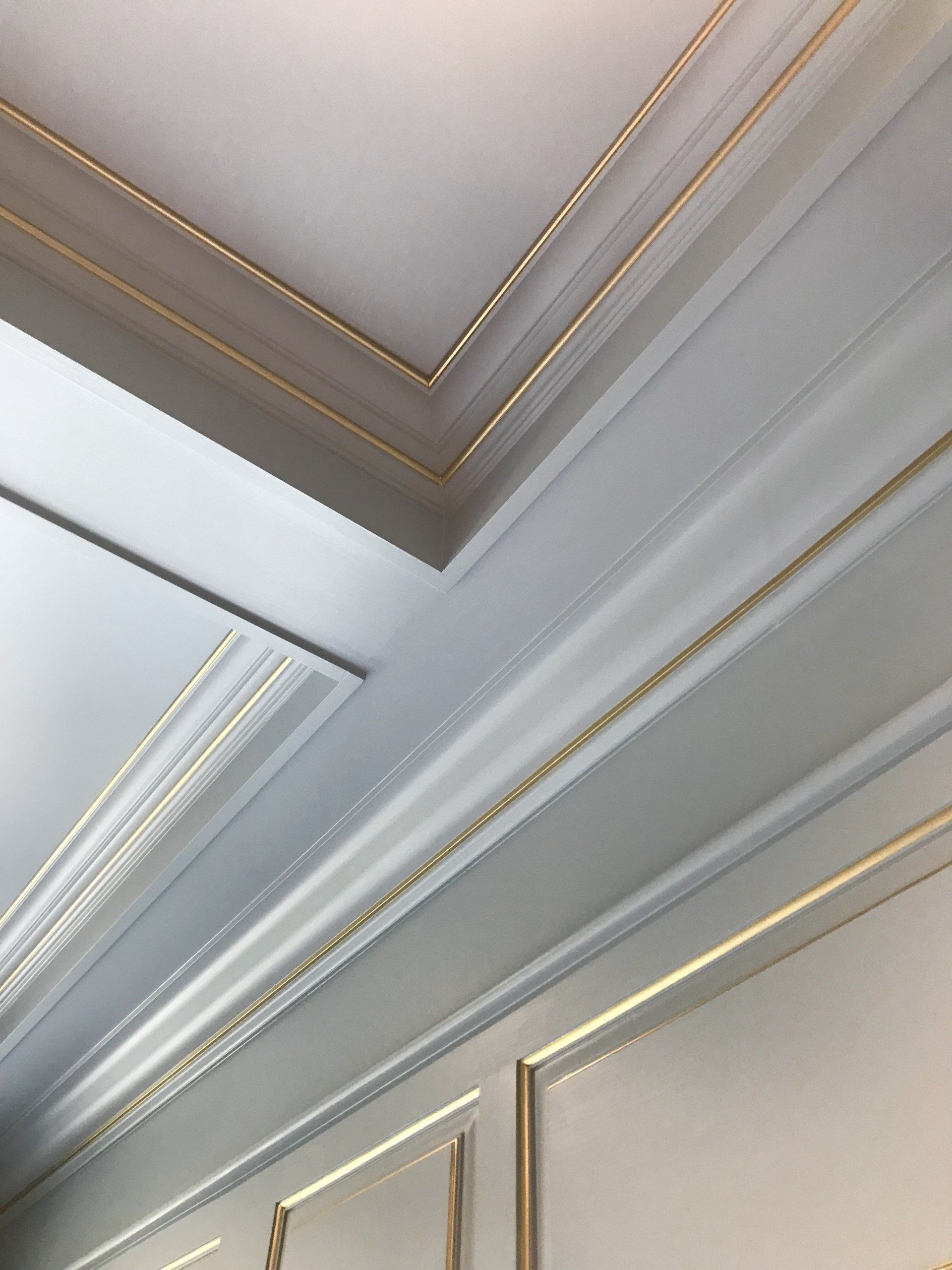 A close up of a white ceiling with gold trim