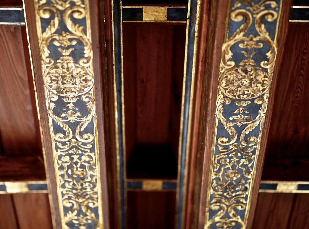 A wooden beam with a gold and black design on it