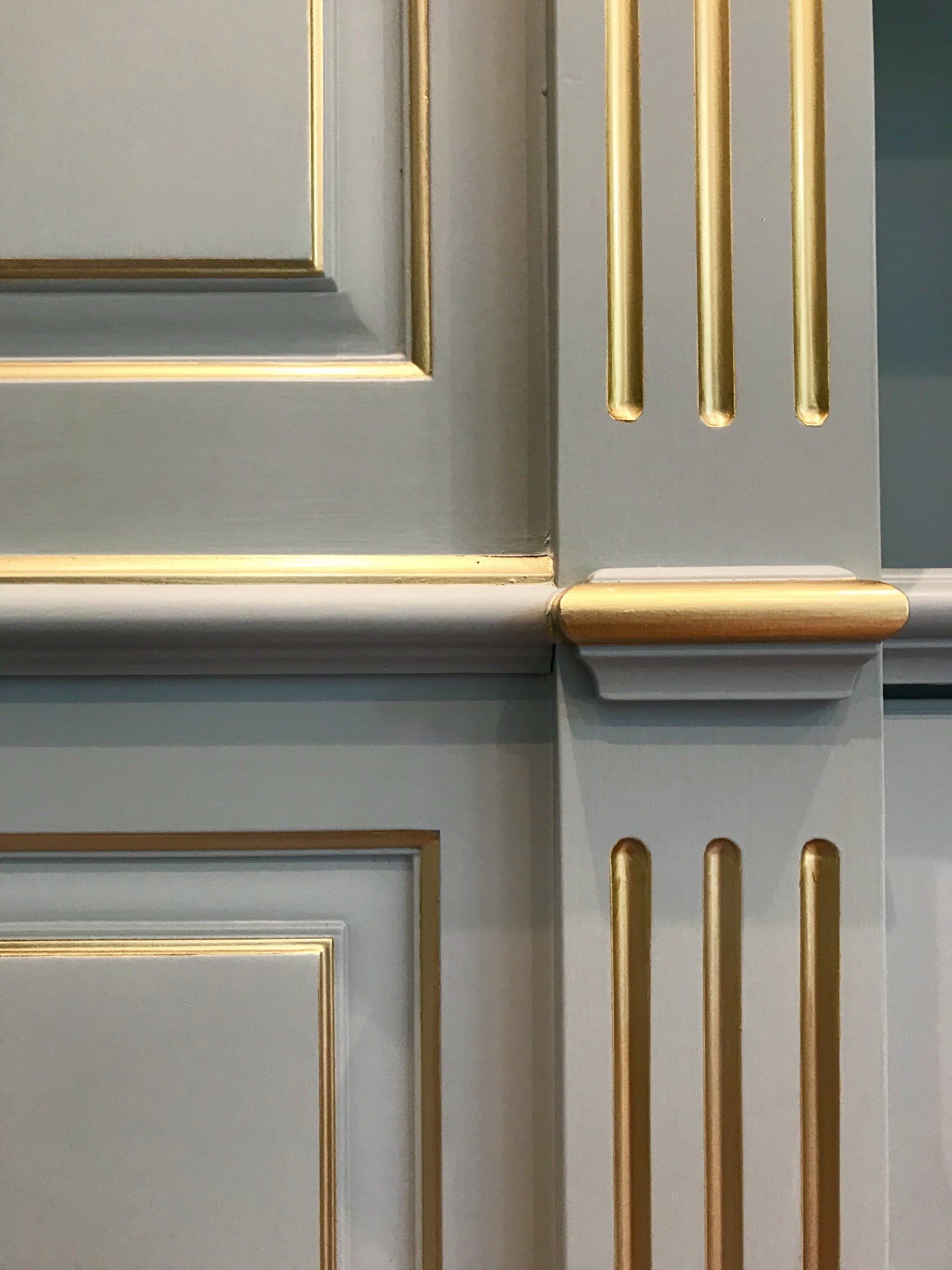A close up of a wooden wall with gold trim.