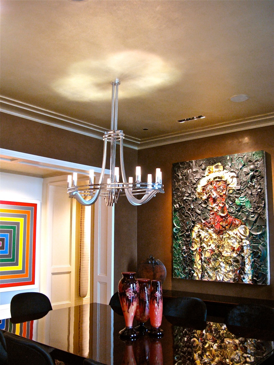 A room with a chandelier and a painting on the wall