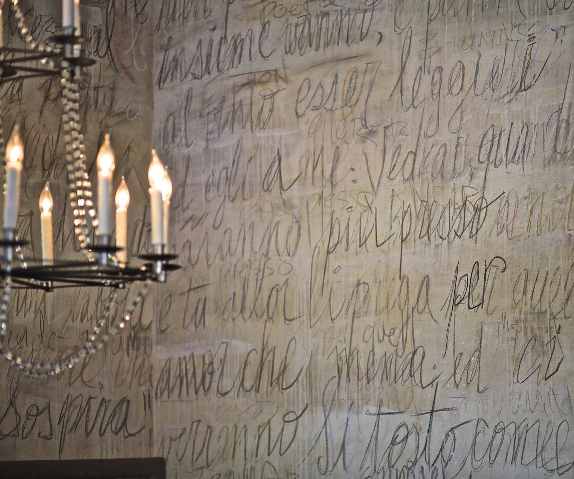 A wall with a lot of writing and candles on it