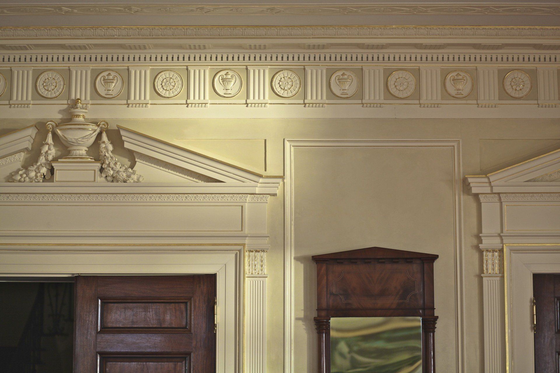 A room with a door and a mirror on the wall.