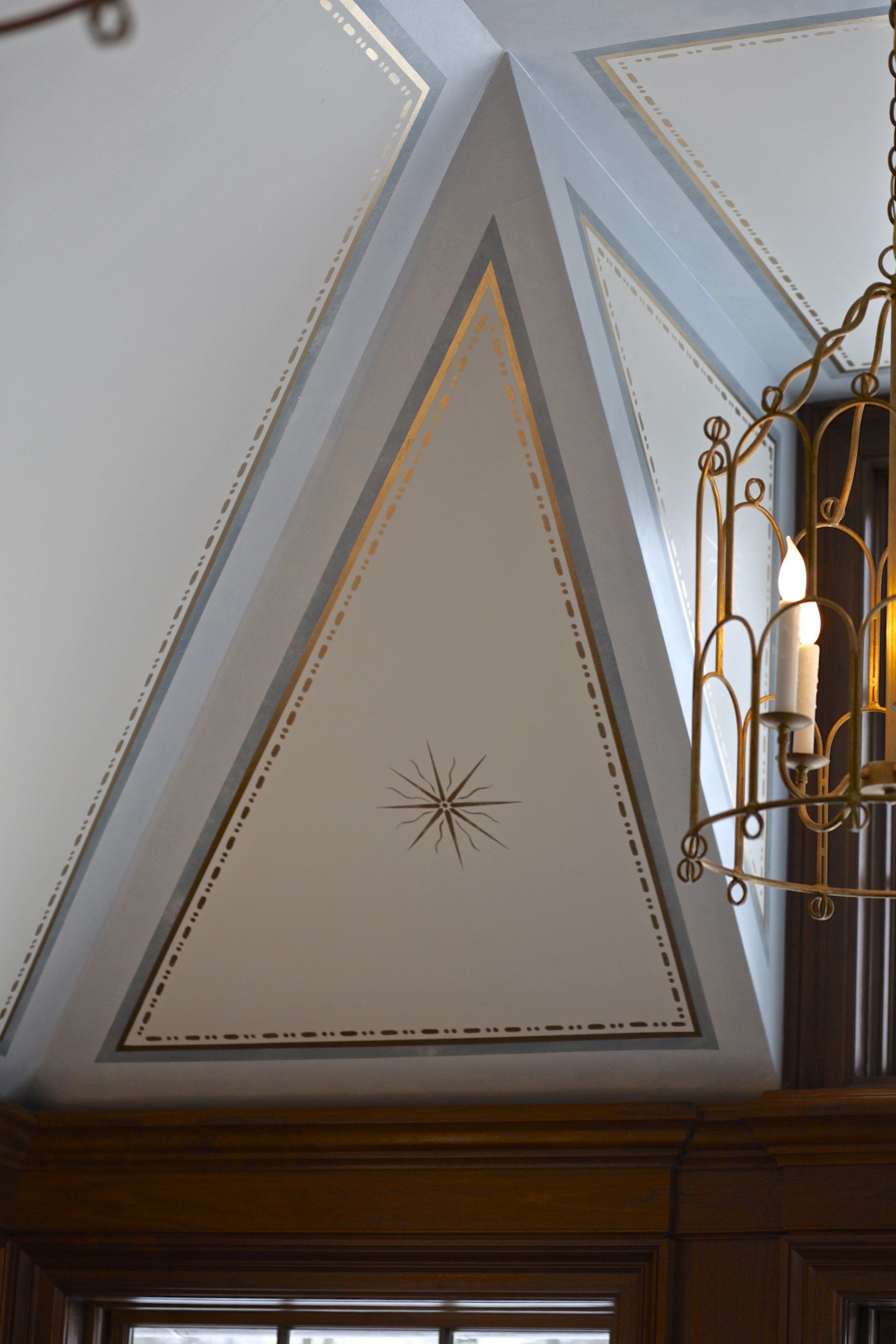 A triangle with a star on it is on the ceiling of a room.