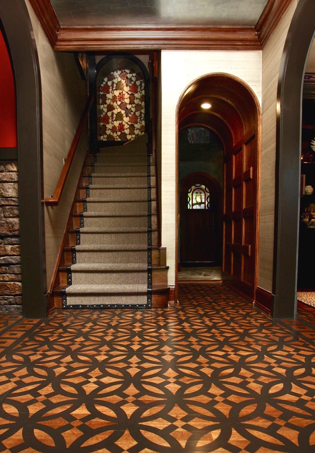 A hallway with stairs and a stained glass window