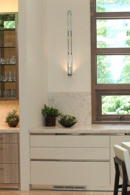 A kitchen with white cabinets and a large window