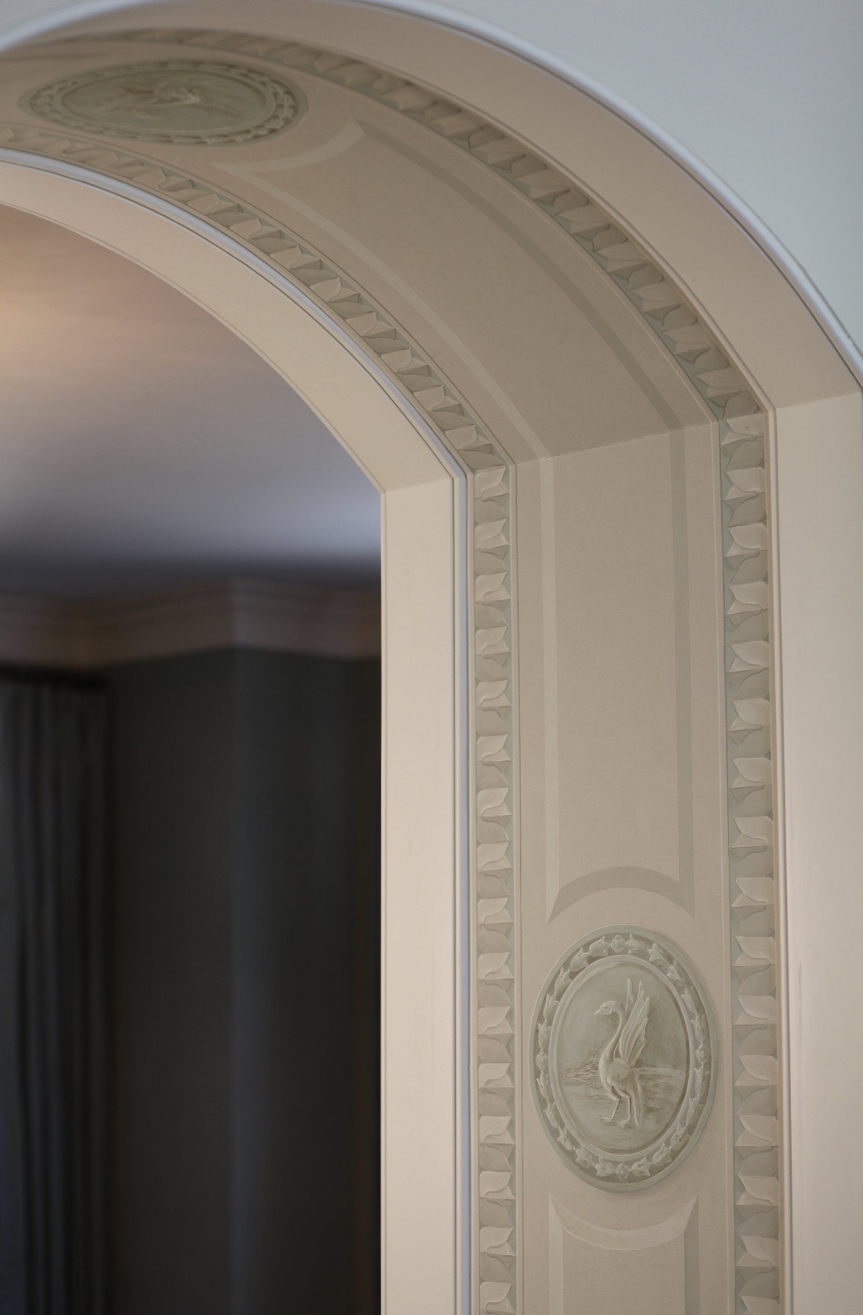 A white archway in a room with a circular design on it.