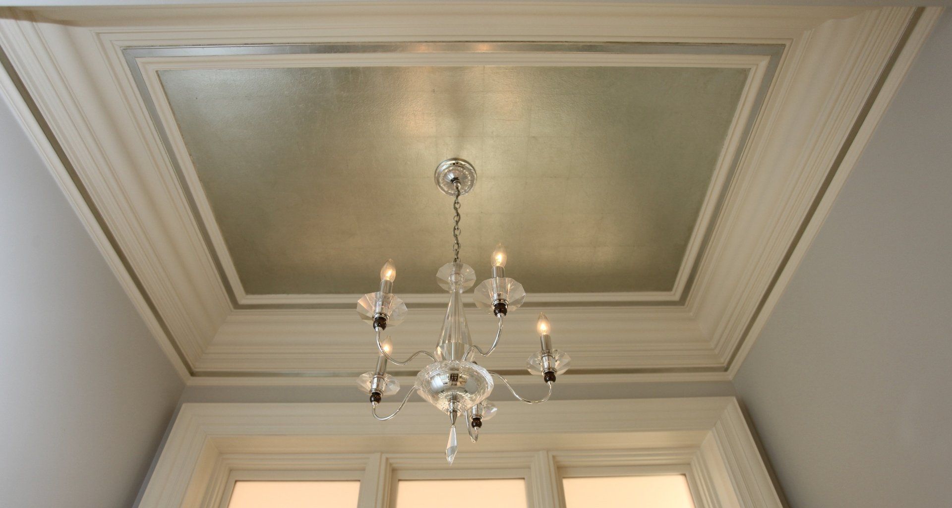 A chandelier is hanging from the ceiling of a room.