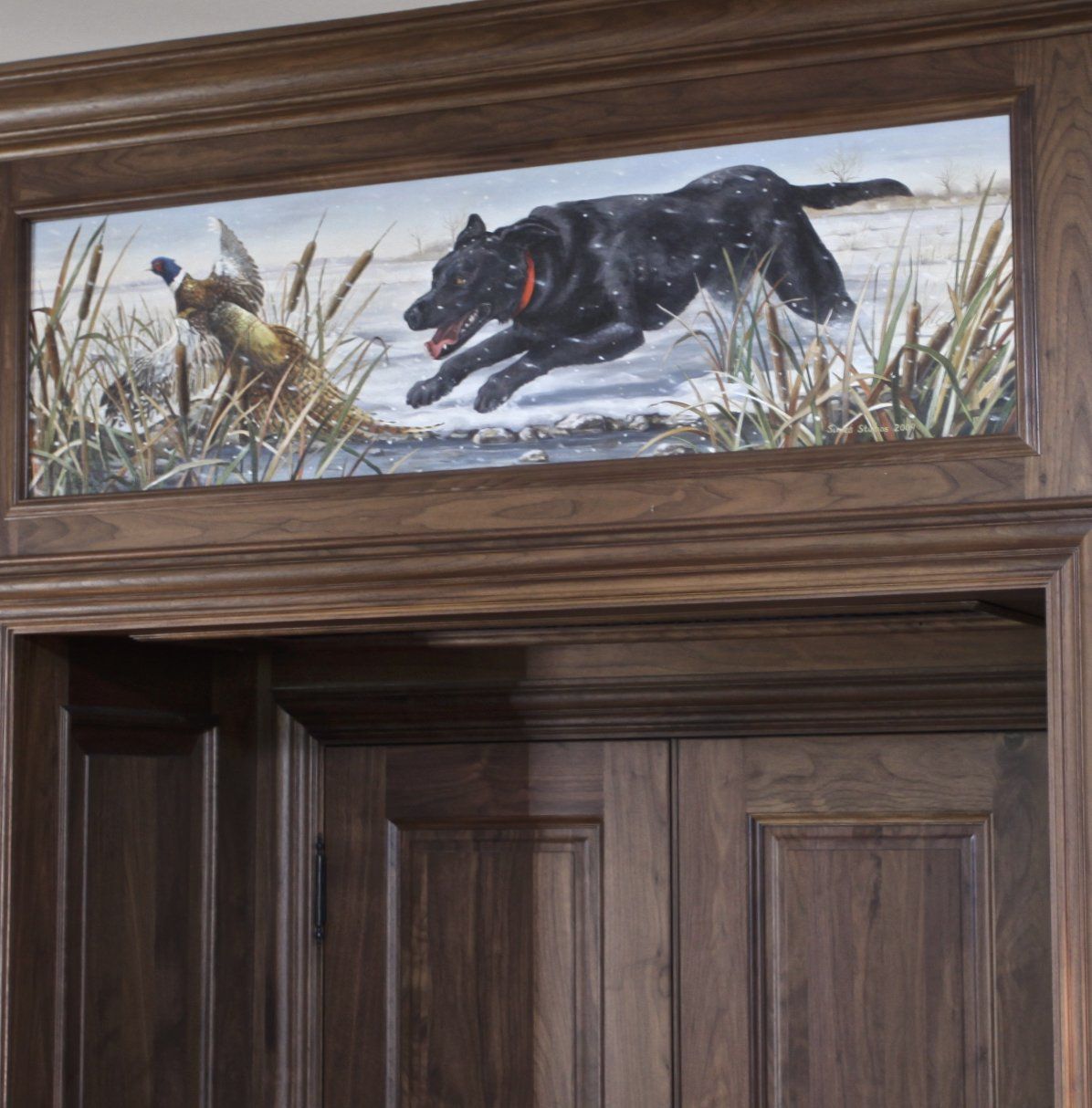 A door with a painting of a black dog chasing a pheasant
