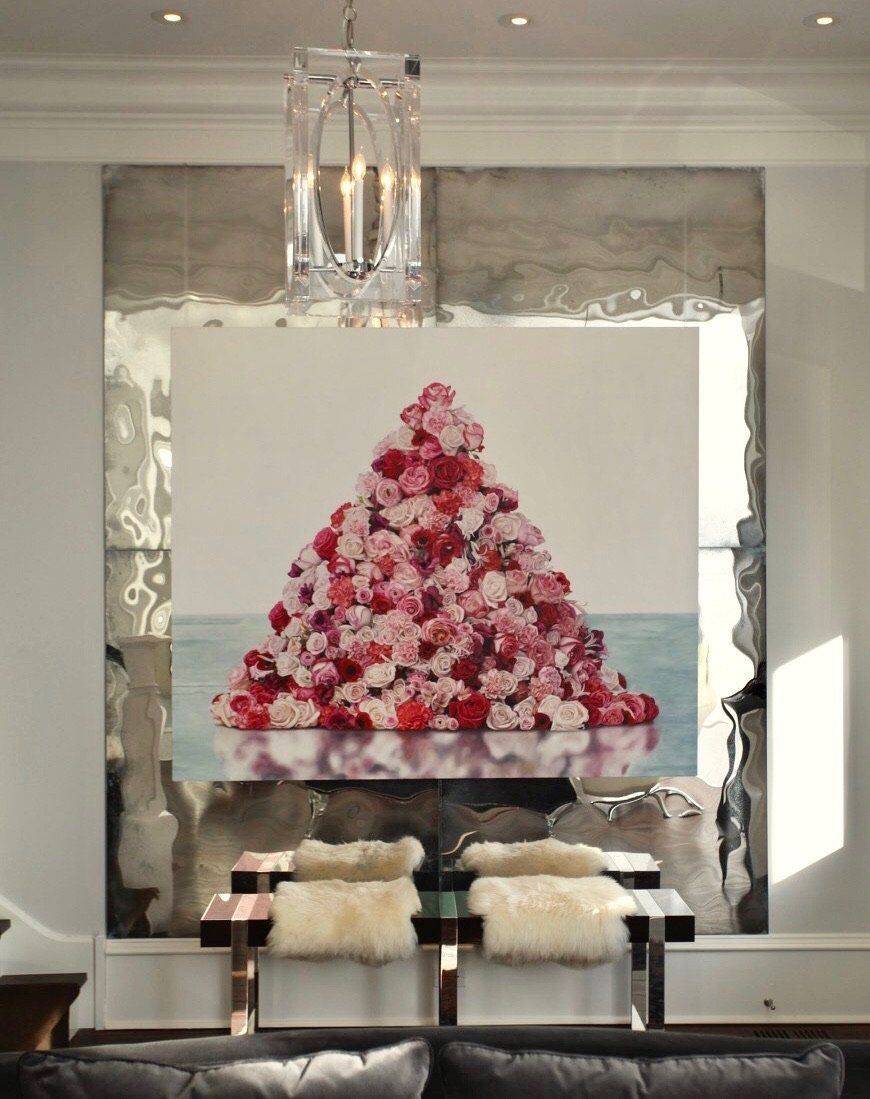 A living room with a painting of flowers in the shape of a triangle