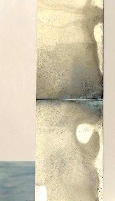 A close up of a painting on a wall with a shadow of a person on it.