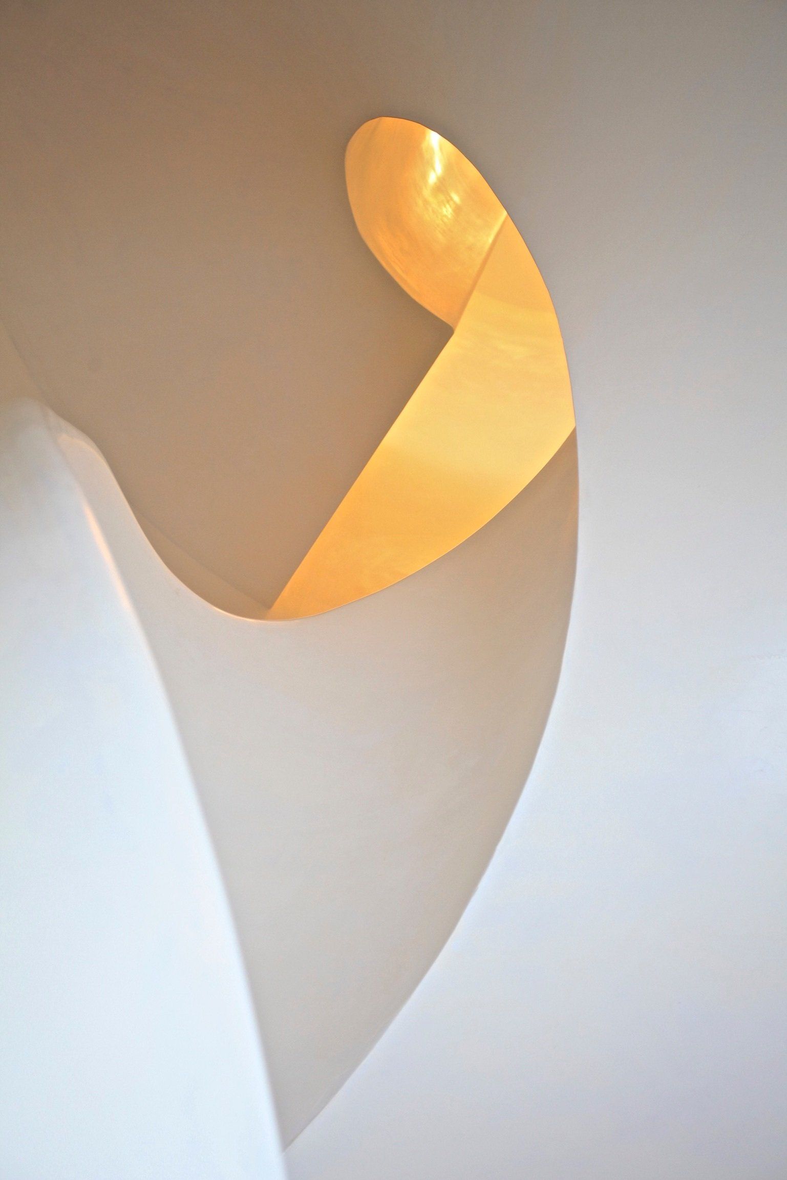 A close up of a spiral staircase with a light coming out of it.