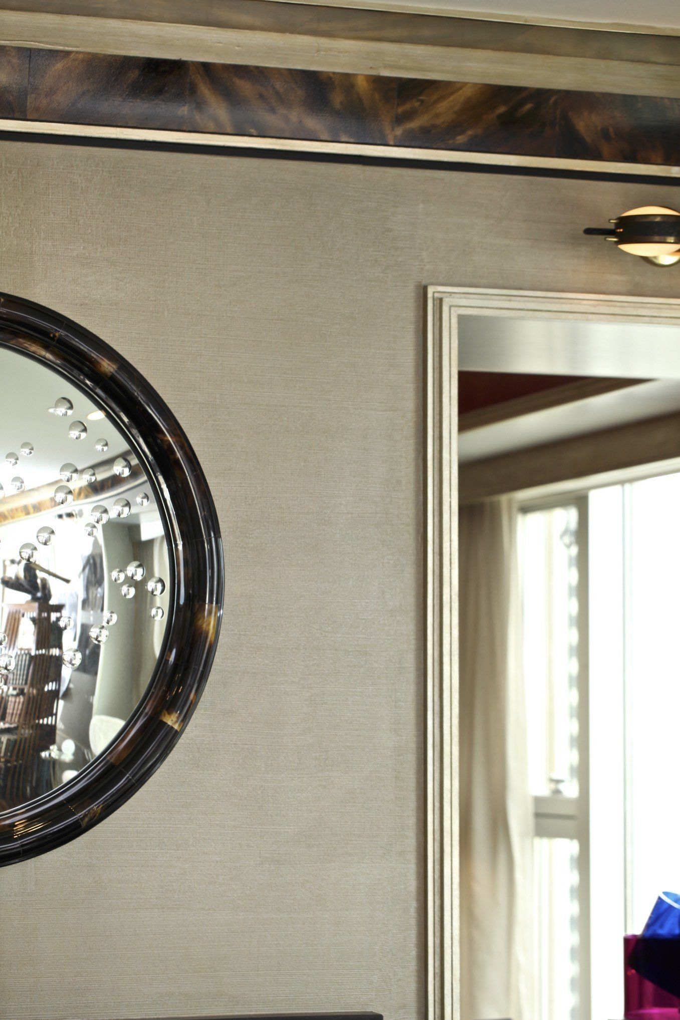 A round mirror is hanging on a wall in a room