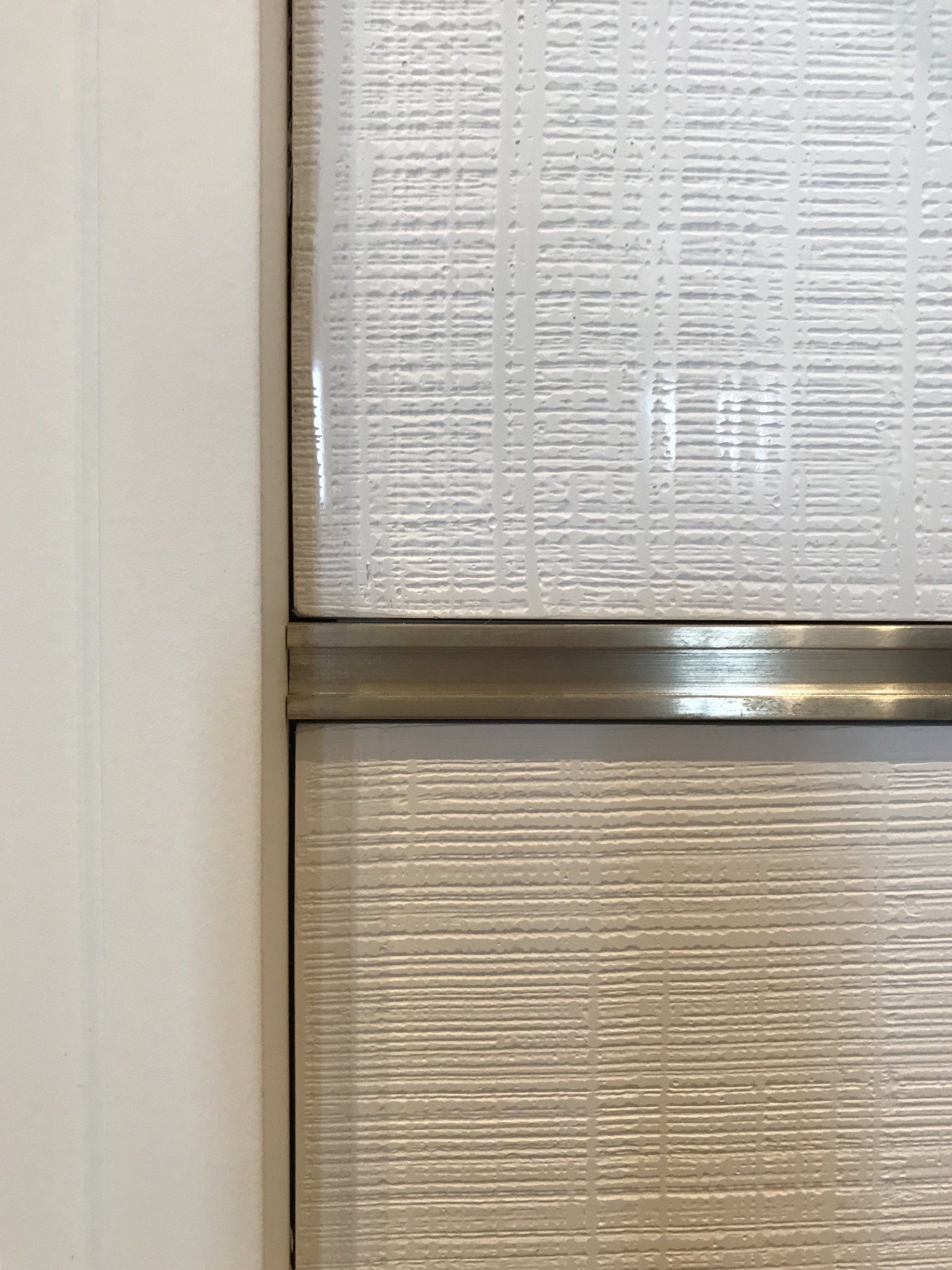 A close up of a door with a stainless steel trim.