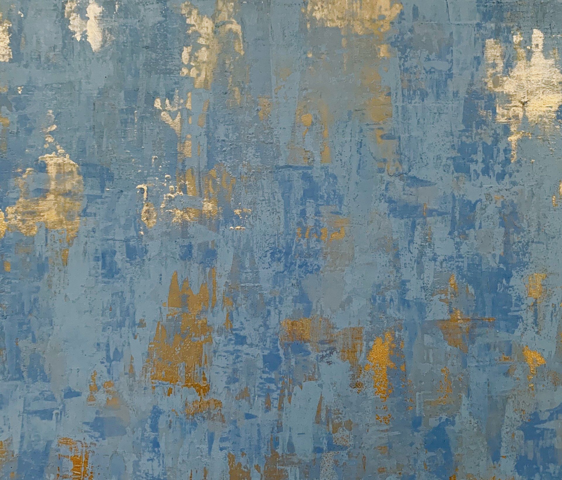 A close up of a blue and gold painting on a wall.