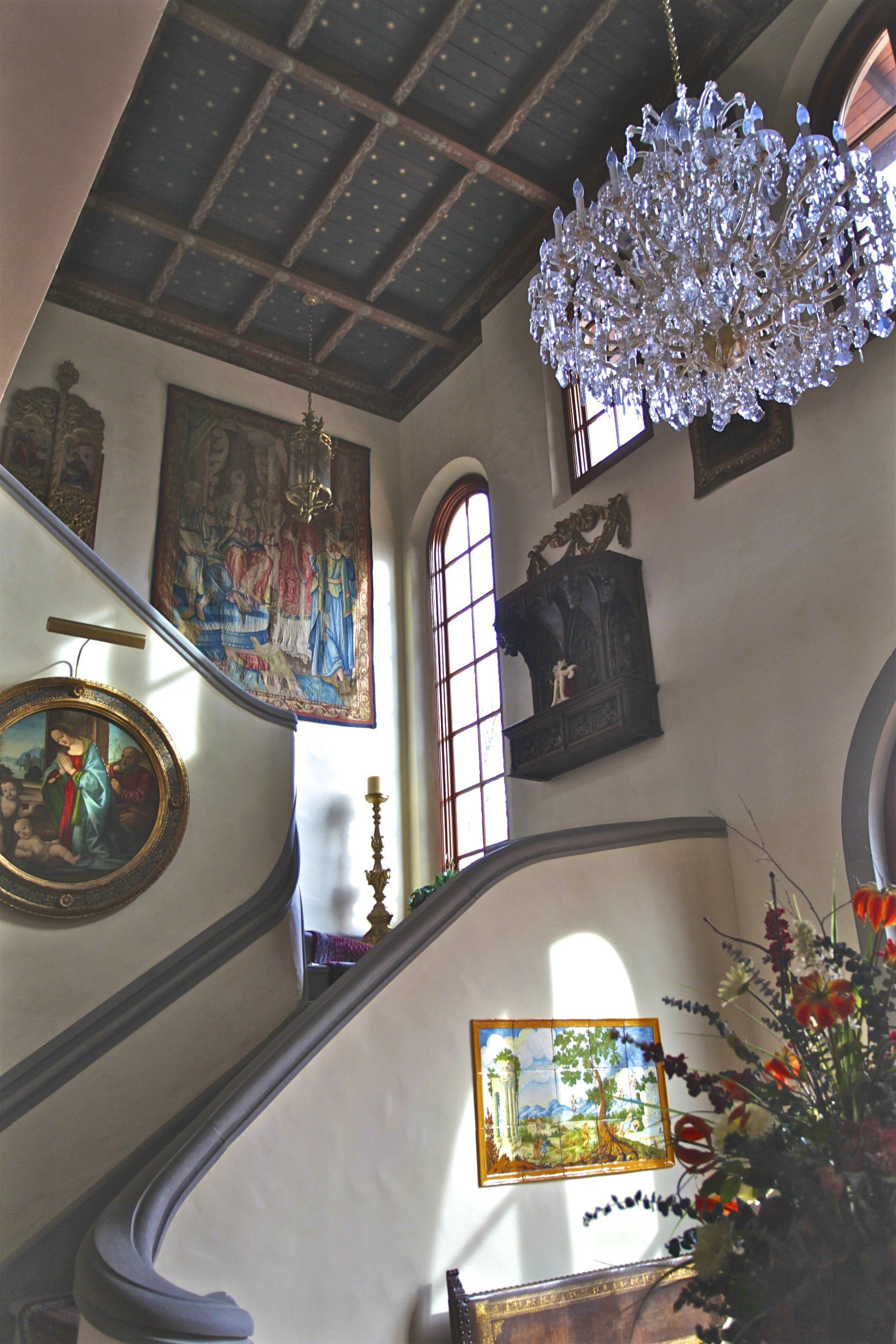 A staircase with a chandelier hanging from the ceiling