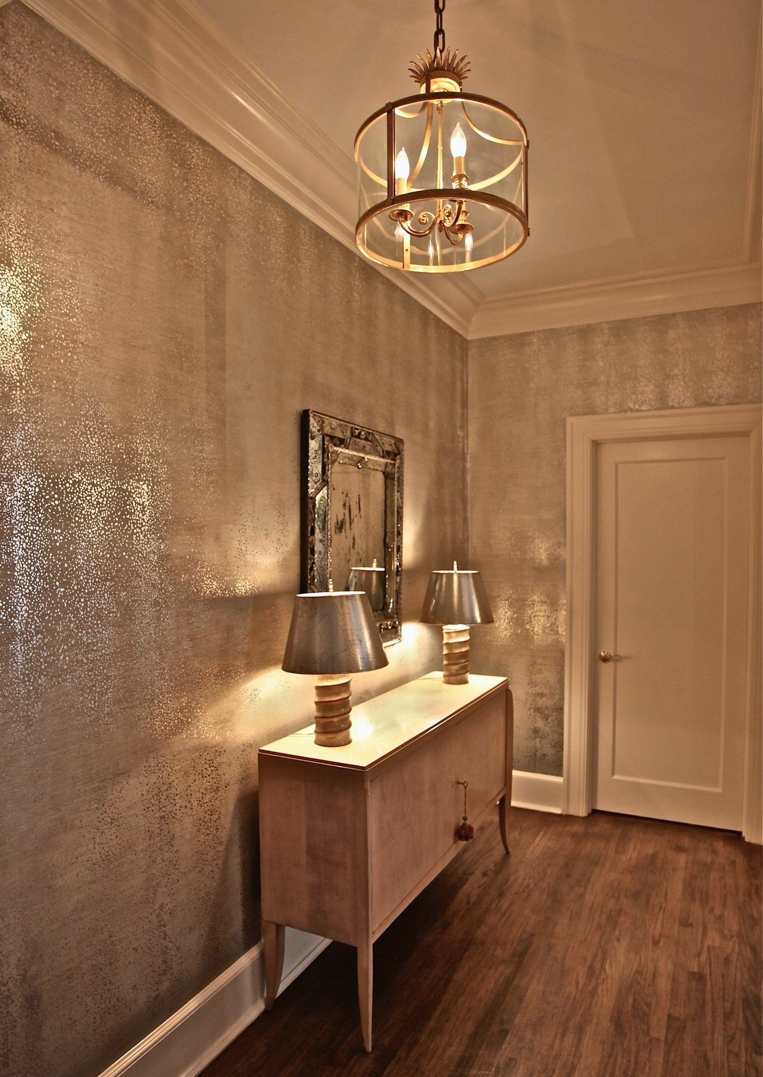 A hallway with a dresser and two lamps