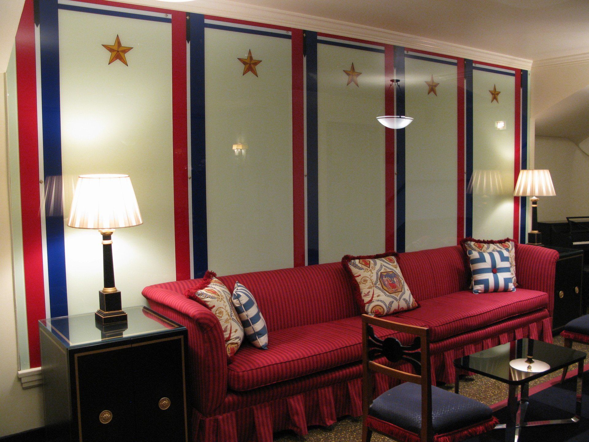 A living room with a red couch and two lamps