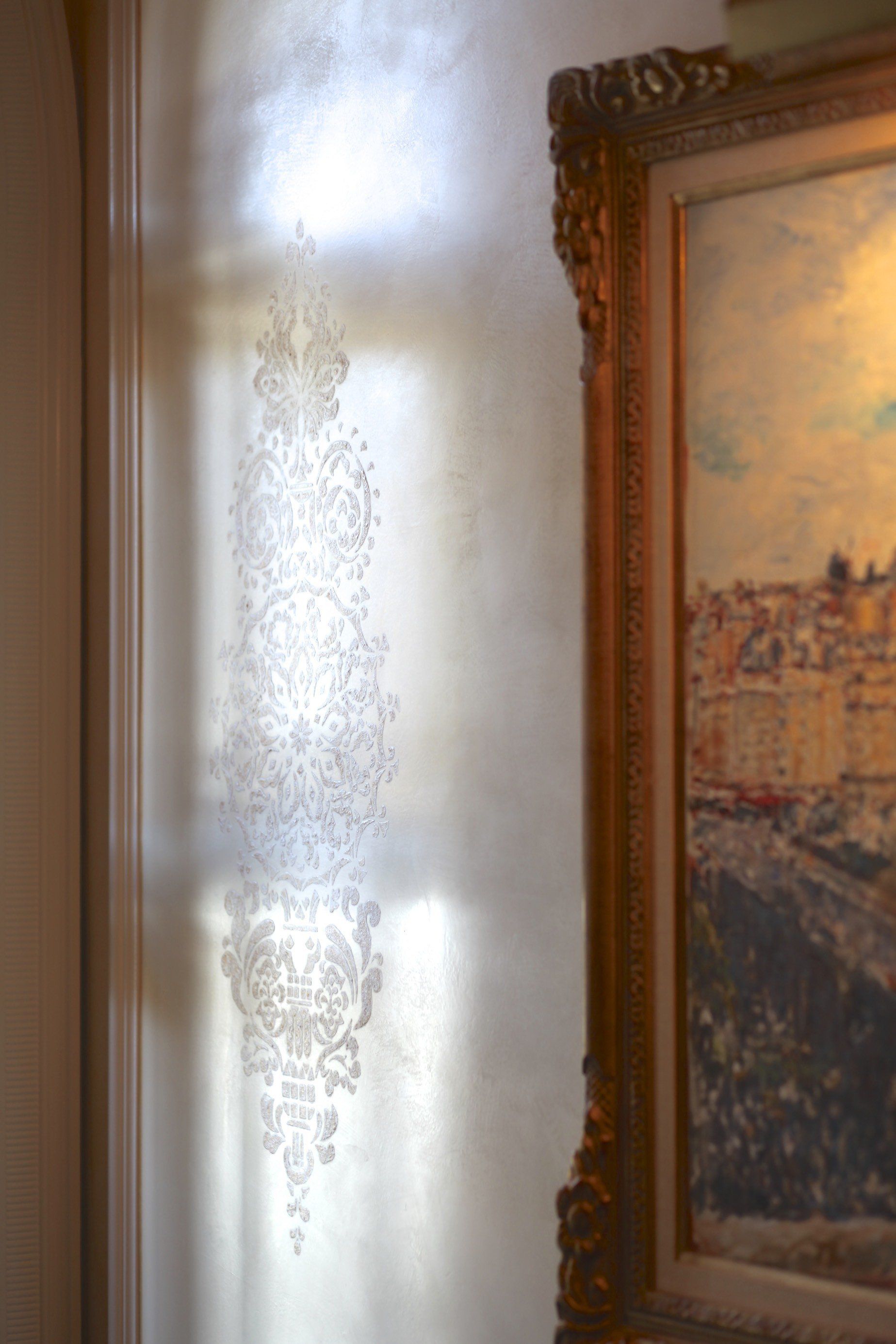 A painting is hanging on a wall next to a window.