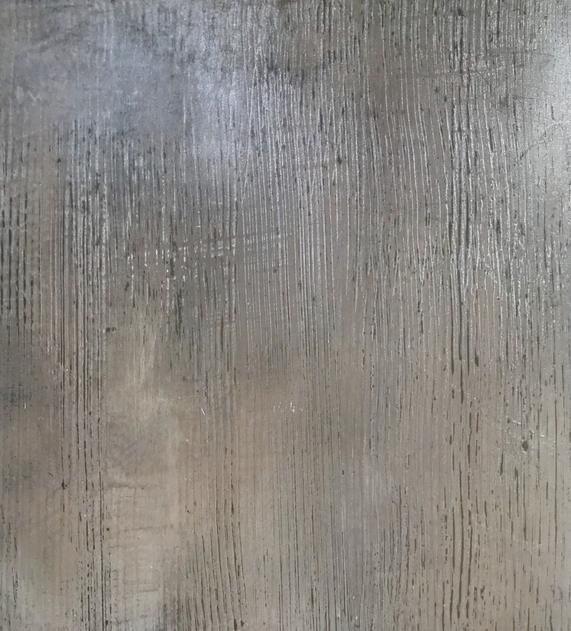 A close up of a gray concrete surface with a grainy texture.