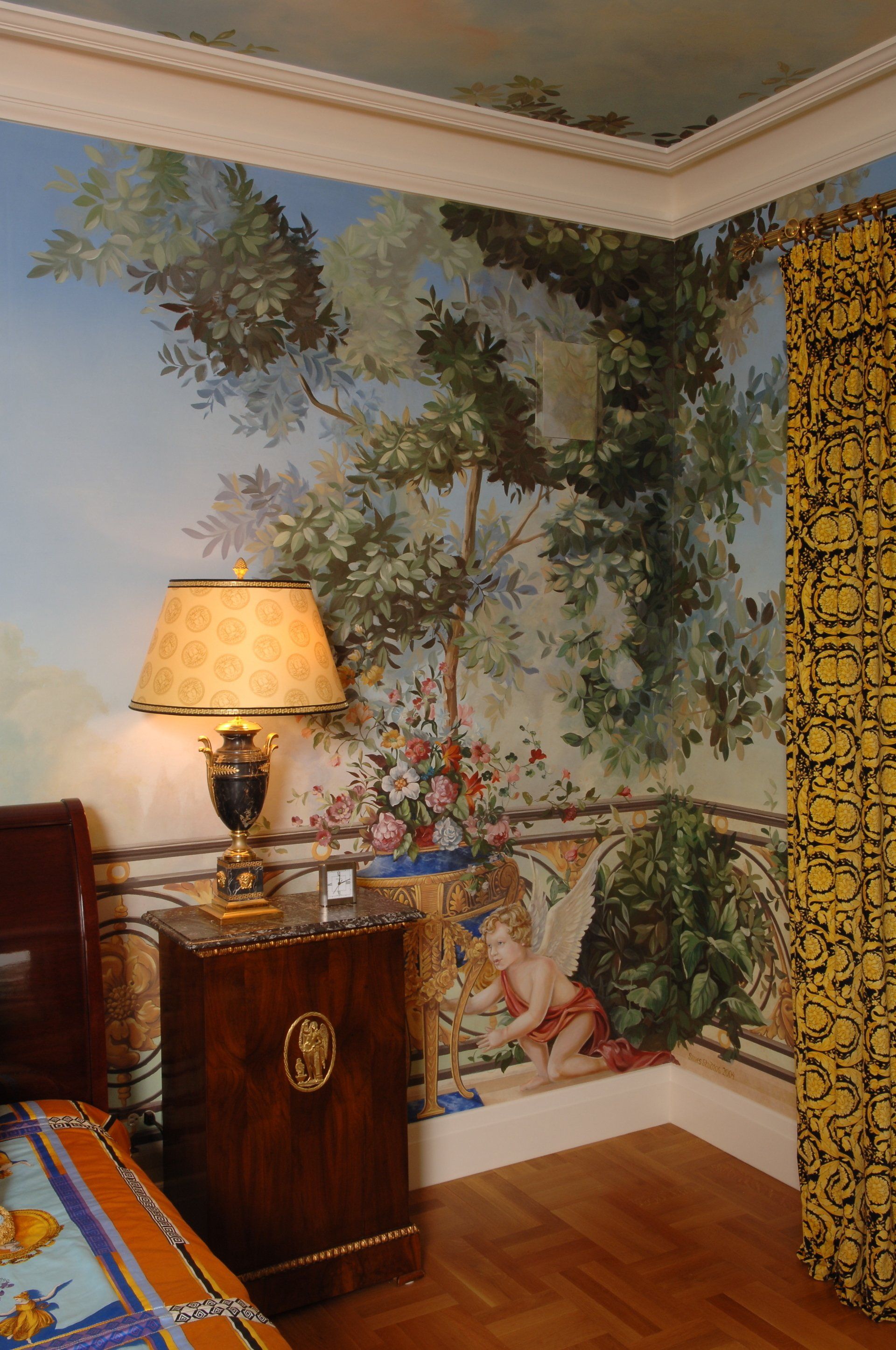 A bedroom with a painting on the wall and a lamp on a nightstand