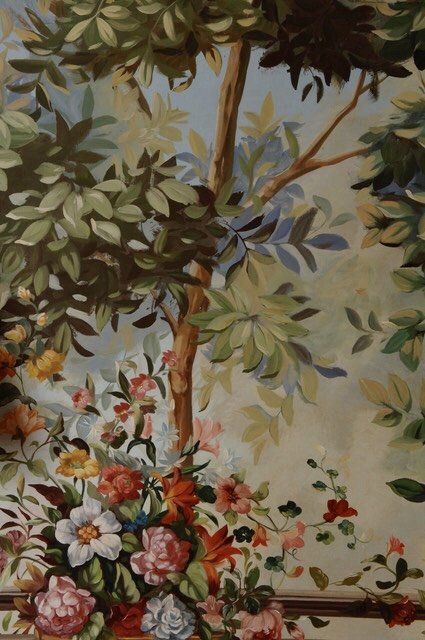 A painting of flowers and trees on a wall