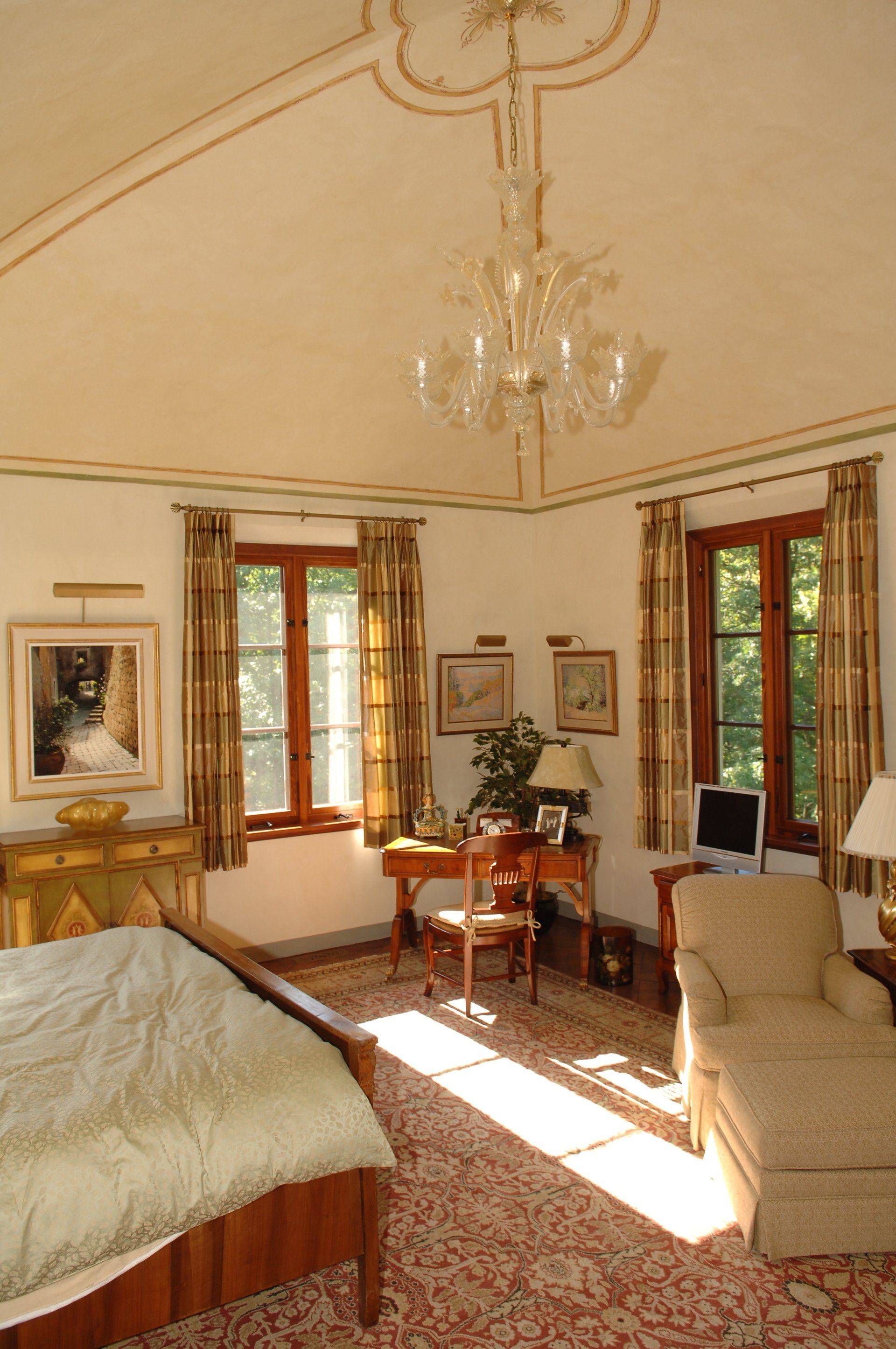 A bedroom with a chandelier hanging from the ceiling
