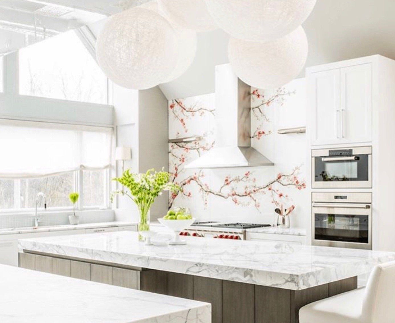 A kitchen with white cabinets and a marble counter top